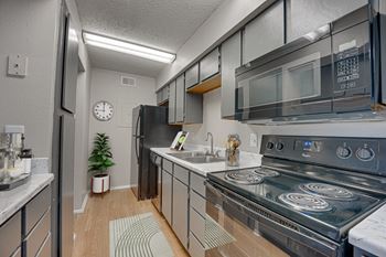 A modern kitchen with a black stove top oven.